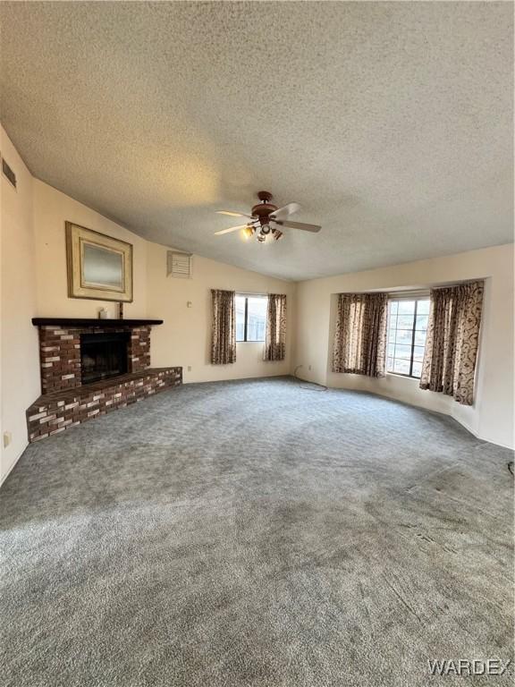 unfurnished living room with a fireplace, carpet flooring, and a wealth of natural light