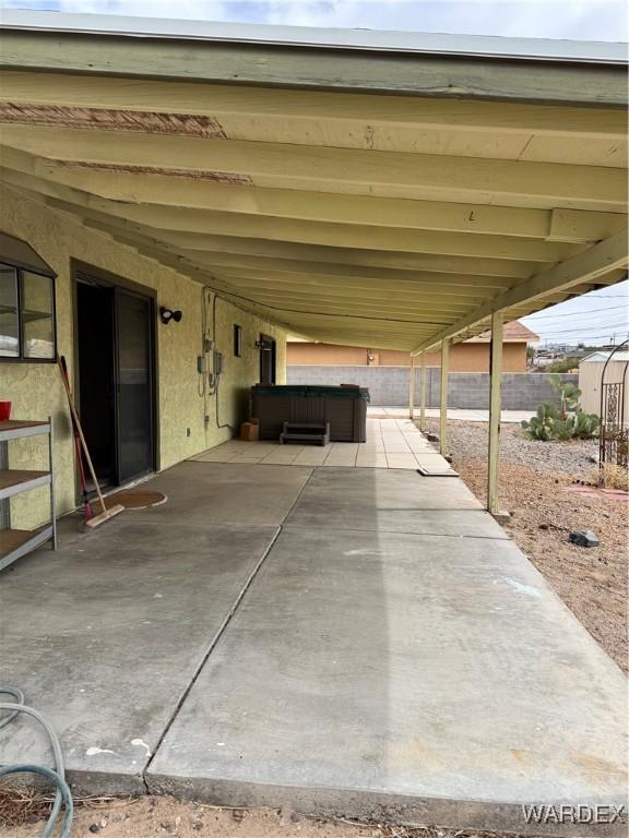 view of patio / terrace with an attached carport and fence