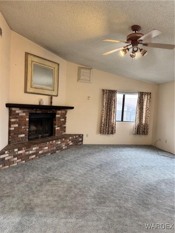 unfurnished living room featuring a textured ceiling, a fireplace, a ceiling fan, and carpet flooring