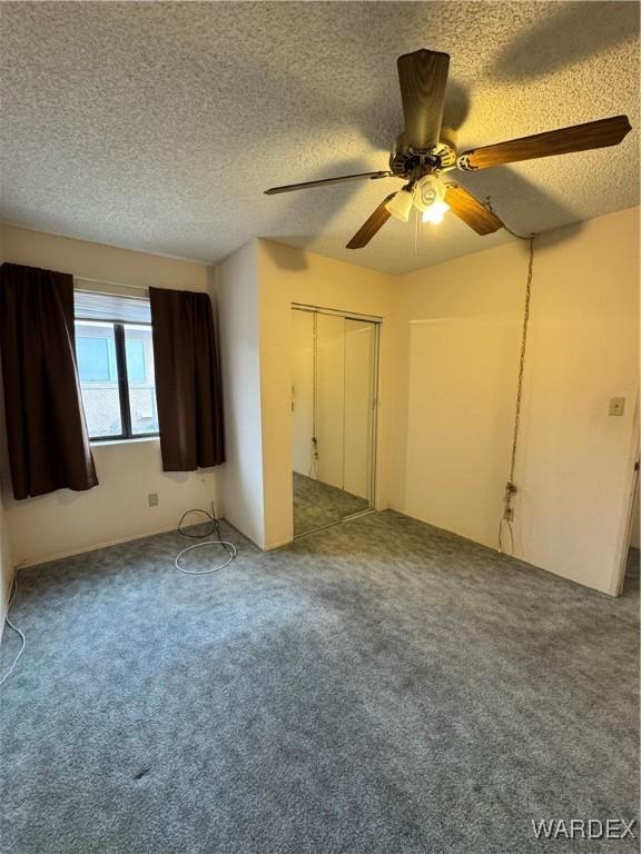 unfurnished bedroom with a ceiling fan, carpet flooring, and a textured ceiling