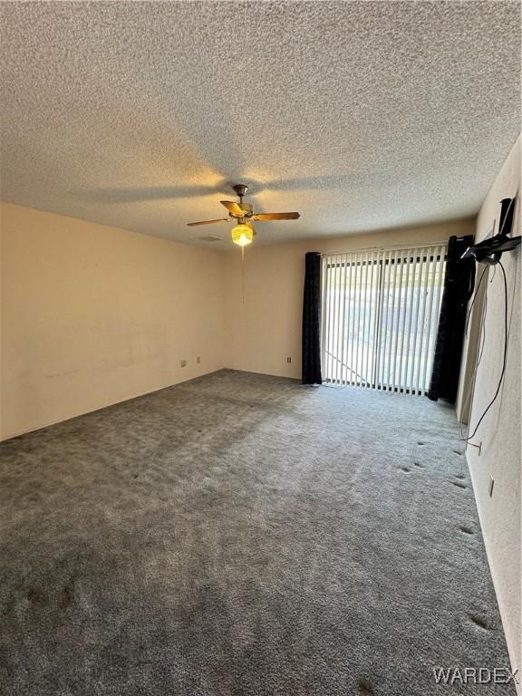 empty room featuring a textured ceiling, ceiling fan, and carpet flooring