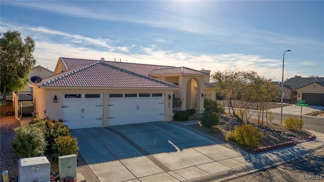 view of front of home with an attached garage, fence, driveway, a tiled roof, and stucco siding