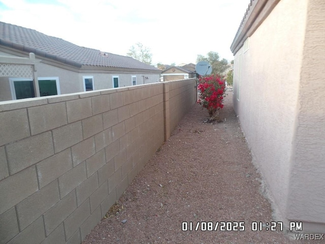 view of side of property featuring fence and stucco siding