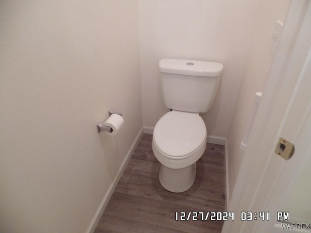 bathroom featuring baseboards, toilet, and wood finished floors