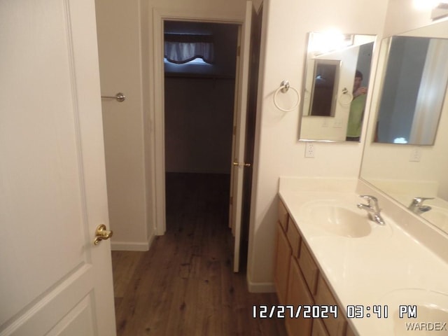 bathroom featuring wood finished floors, vanity, and baseboards