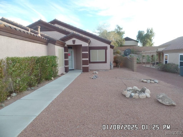 view of front of property featuring a tile roof and stucco siding