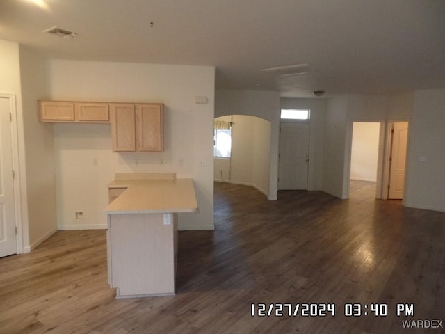 kitchen featuring arched walkways, light brown cabinets, dark wood-style flooring, visible vents, and light countertops