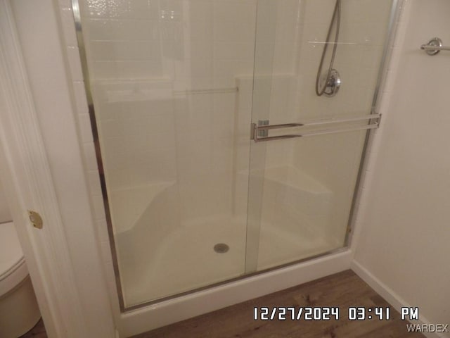 full bath with a shower stall, toilet, and baseboards