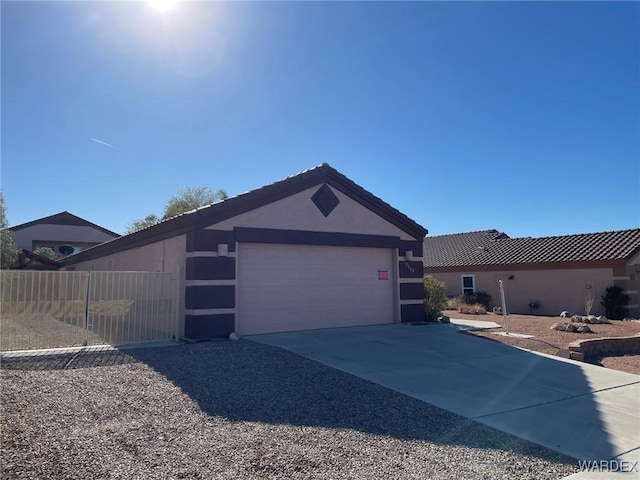 view of front of property with an attached garage, fence, concrete driveway, and stucco siding