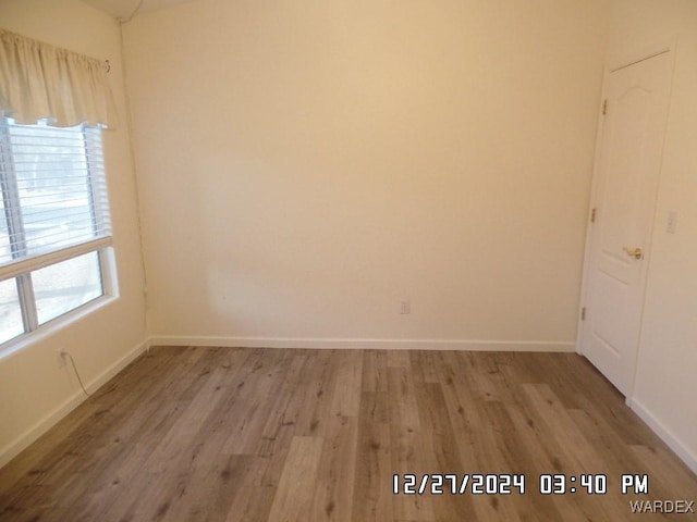 unfurnished room featuring light wood finished floors and baseboards