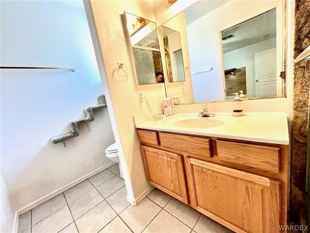 bathroom featuring toilet, vanity, baseboards, and tile patterned floors