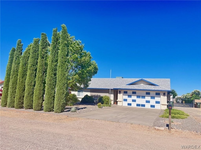 ranch-style house featuring a garage, fence, and concrete driveway