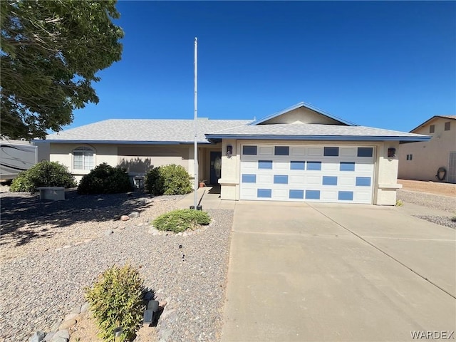 single story home featuring an attached garage, concrete driveway, and stucco siding