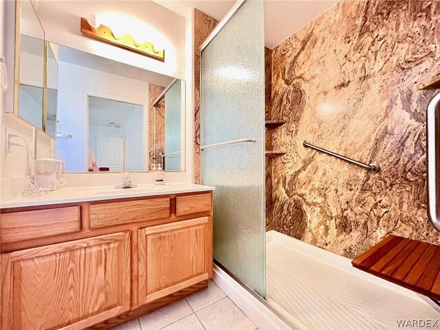 full bathroom with tile patterned flooring, vanity, and a shower stall