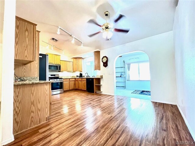 kitchen with visible vents, arched walkways, a ceiling fan, stainless steel appliances, and light wood-type flooring