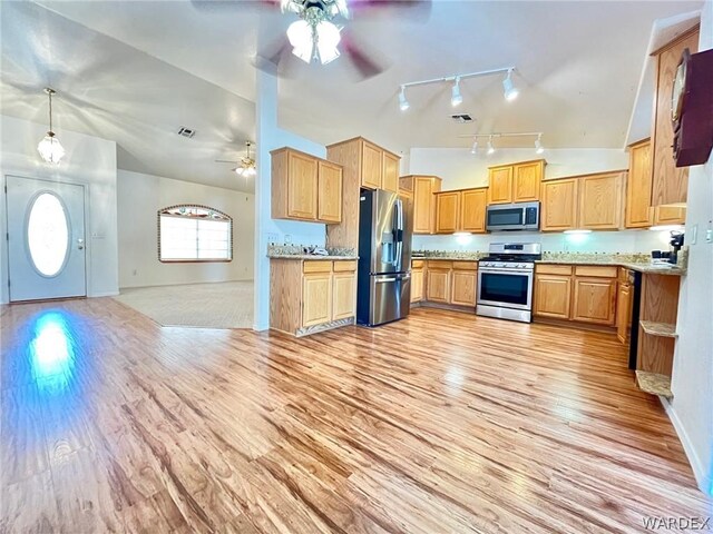 kitchen with appliances with stainless steel finishes, lofted ceiling, open floor plan, and light wood-type flooring