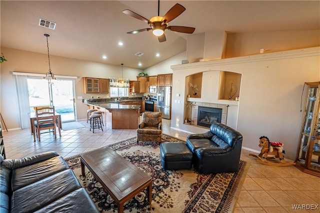 living room with light tile patterned floors, visible vents, and a tiled fireplace