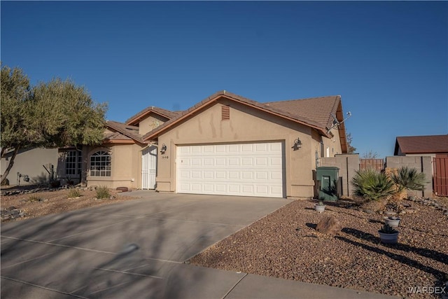 view of front of home with driveway, an attached garage, a tiled roof, and stucco siding