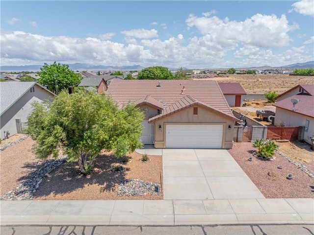 view of front of house featuring a garage, a gate, a tile roof, stucco siding, and fence