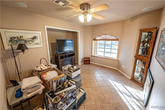 living room featuring light tile patterned floors, ceiling fan, visible vents, and baseboards