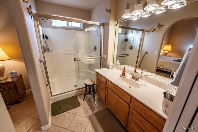 bathroom with a stall shower, tile patterned flooring, ensuite bath, and vanity