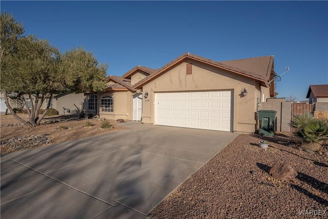 ranch-style home with driveway, an attached garage, a tile roof, and stucco siding