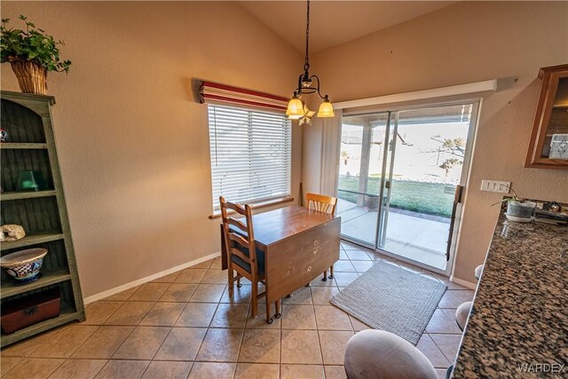 dining area with vaulted ceiling, light tile patterned floors, and baseboards