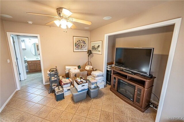 living room with baseboards, a ceiling fan, and light tile patterned flooring