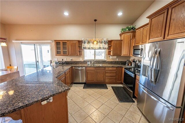 kitchen with brown cabinetry, glass insert cabinets, stainless steel appliances, open shelves, and a sink