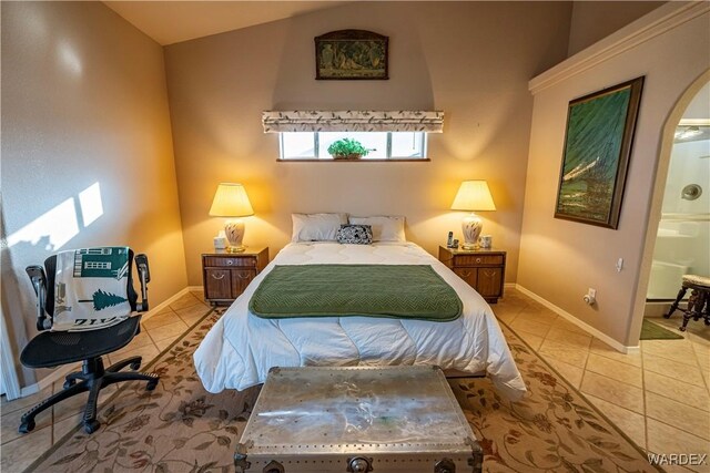 bedroom featuring vaulted ceiling, light tile patterned flooring, and baseboards