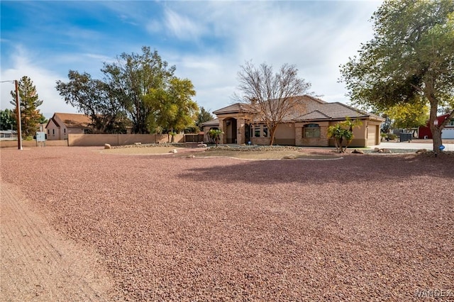 view of front of property featuring a garage, fence, and concrete driveway