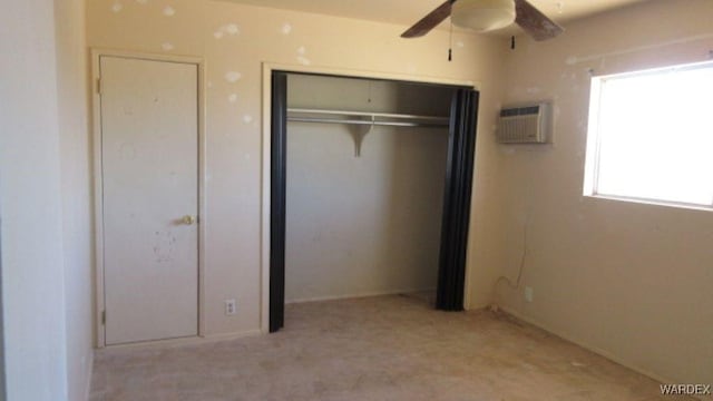 unfurnished bedroom featuring a ceiling fan, a closet, and a wall mounted air conditioner