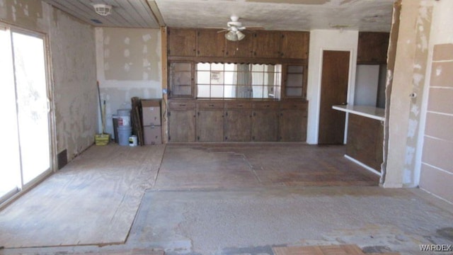 interior space with ceiling fan and light countertops