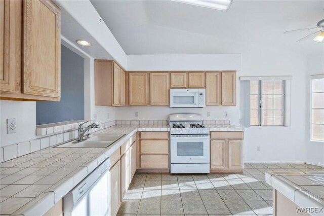 kitchen featuring tile counters, white appliances, light brown cabinets, and a sink