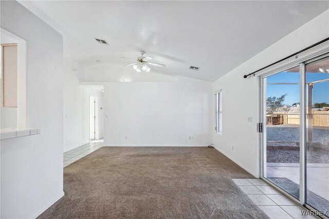 empty room featuring vaulted ceiling, a ceiling fan, visible vents, and light colored carpet