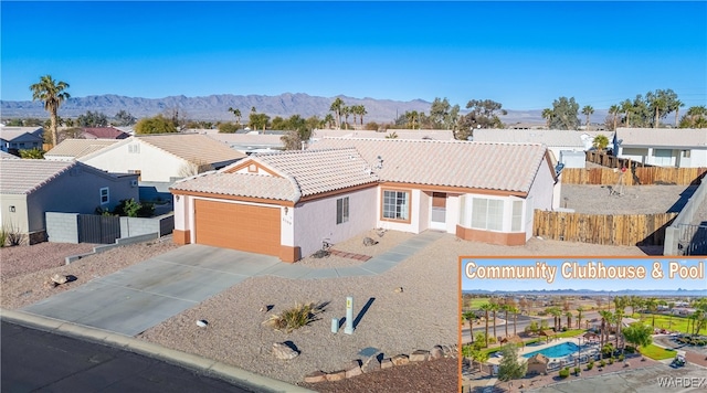 view of front of property with concrete driveway, a tile roof, a mountain view, and stucco siding