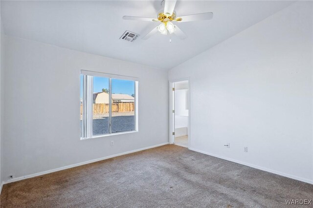 spare room with ceiling fan, light colored carpet, visible vents, baseboards, and vaulted ceiling