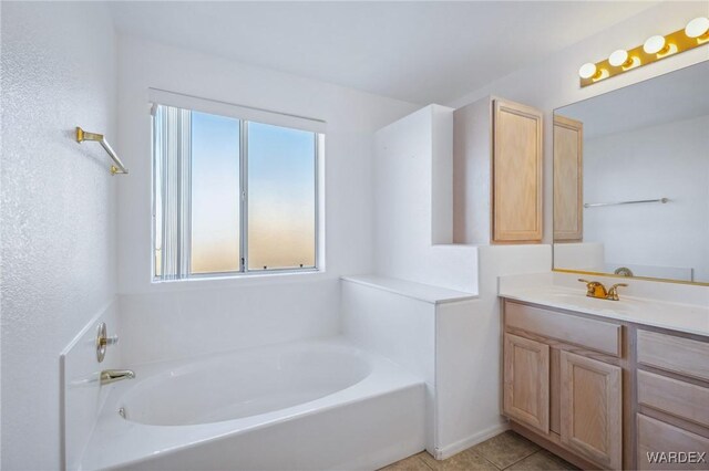 full bathroom with a garden tub, vanity, and tile patterned floors