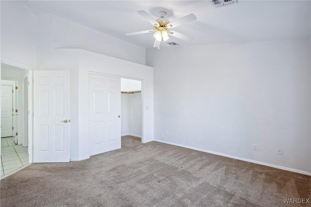 unfurnished bedroom featuring vaulted ceiling, carpet, visible vents, and a ceiling fan