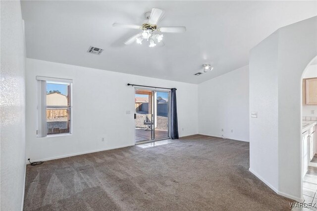 carpeted spare room with visible vents, plenty of natural light, baseboards, and ceiling fan