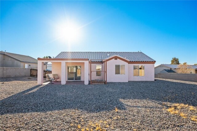 back of property with a patio area, a tile roof, a fenced backyard, and stucco siding