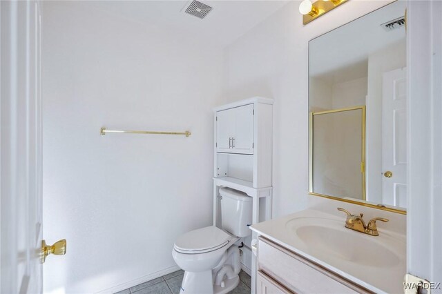 bathroom featuring vanity, an enclosed shower, visible vents, and tile patterned floors