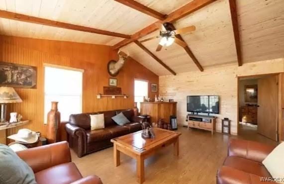 living room featuring vaulted ceiling with beams, wood walls, wood finished floors, wood ceiling, and a ceiling fan