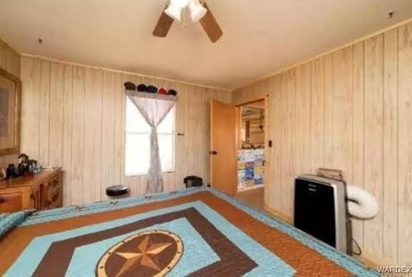 bedroom with wood walls and ceiling fan