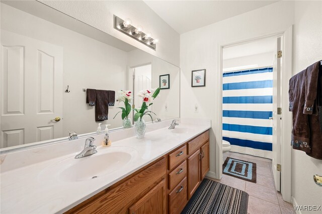 full bath with double vanity, tile patterned flooring, toilet, and a sink