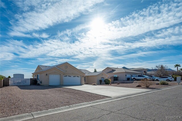 single story home featuring a garage, a gate, a residential view, and concrete driveway