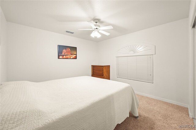 carpeted bedroom with a ceiling fan, visible vents, and baseboards