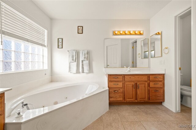 full bathroom with toilet, a whirlpool tub, vanity, and tile patterned floors