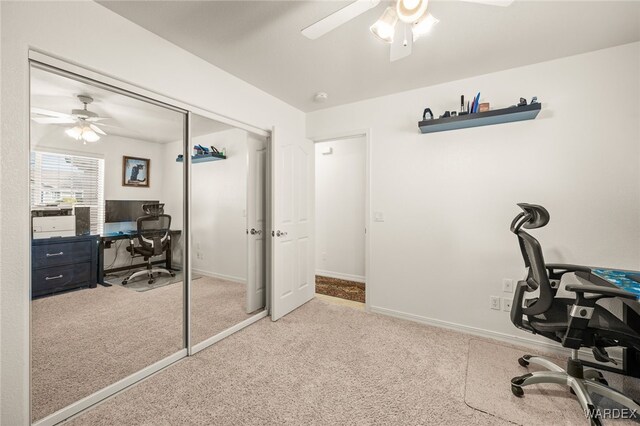 office area with carpet floors, a ceiling fan, and baseboards