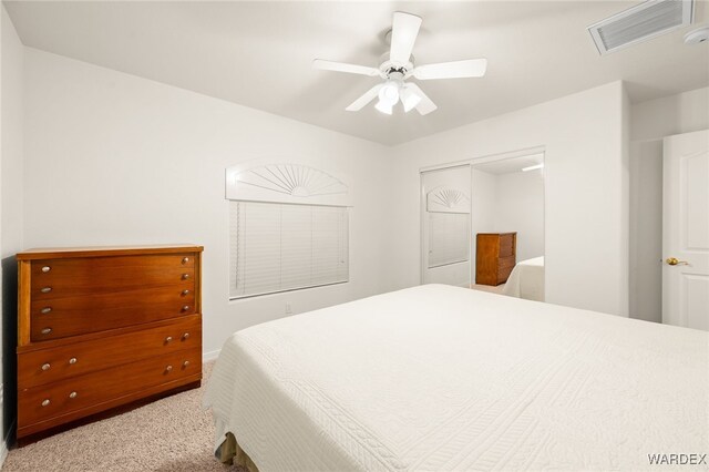 bedroom with light carpet, ceiling fan, visible vents, and a closet